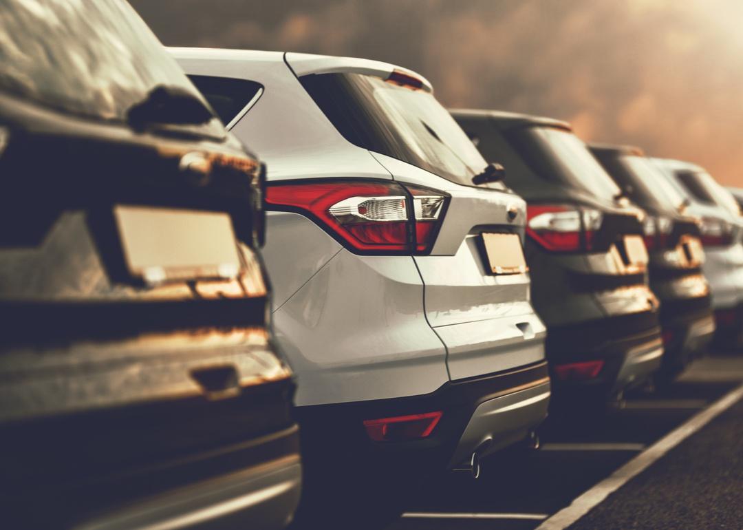 A line of small SUV's with ominous sky in background.