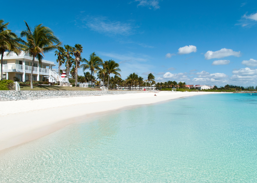 Homes on white sandy beach with crystal clear water.