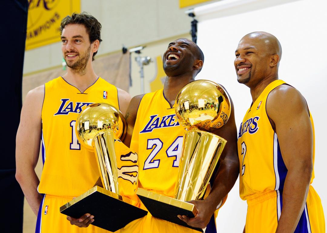 Kobe Bryant laughs as he holds two NBA Finals Trophy's with teammates Pau Gasol and Derek Fisher. 