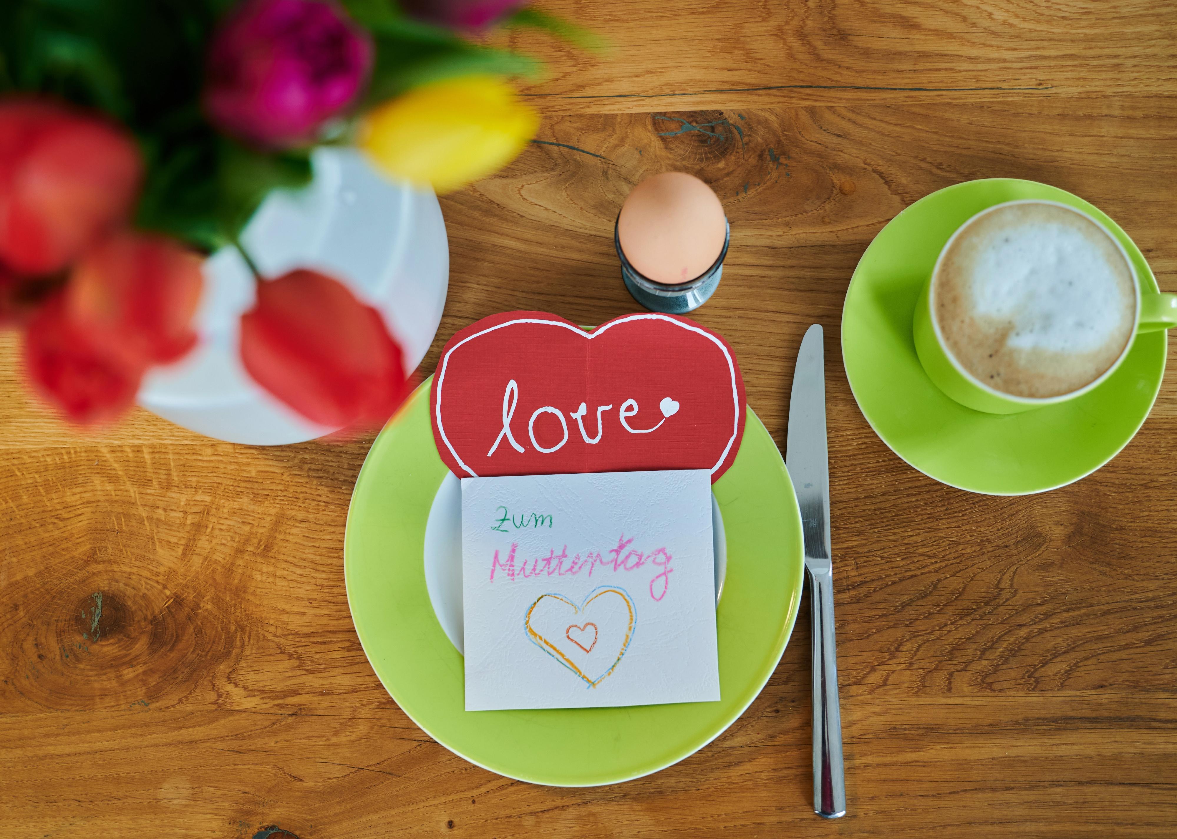 Aerial view of "Happy Mother's Day" and "love" in German on homemade cards