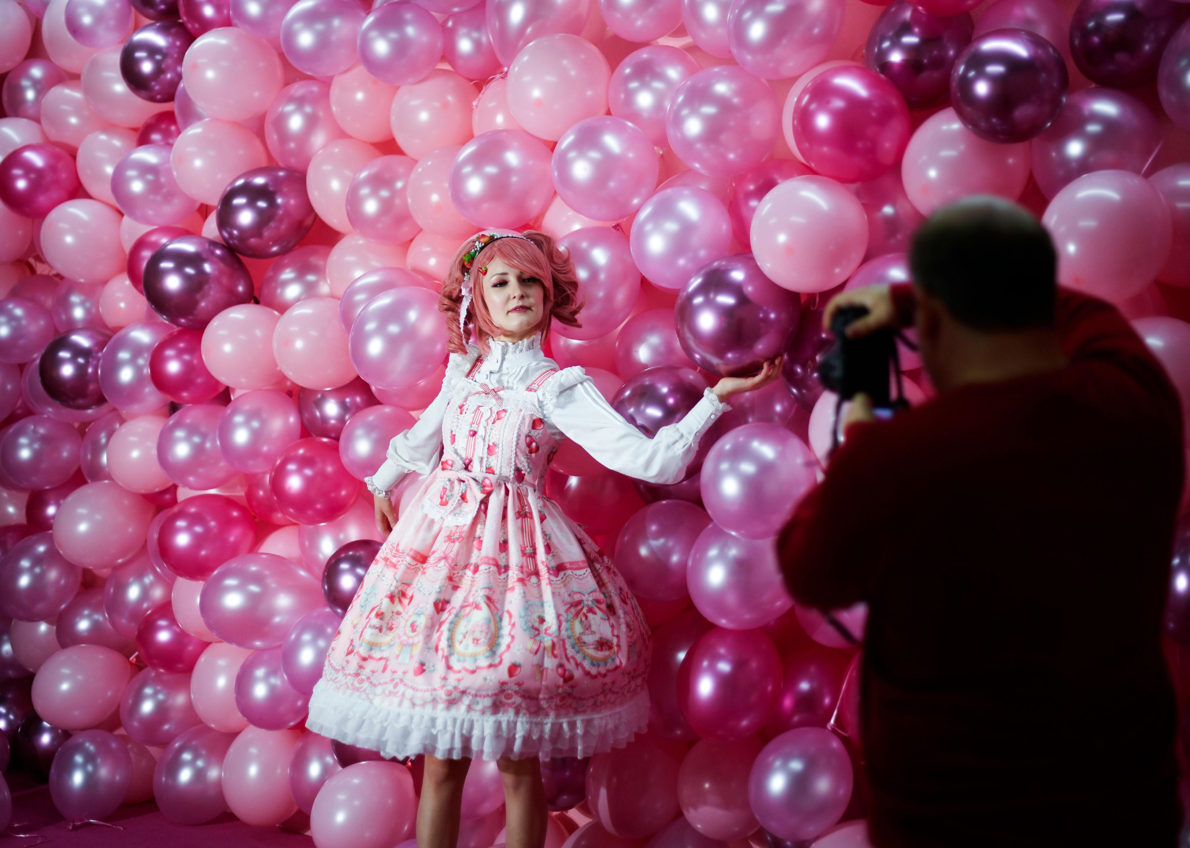 Instagram influencer "Anmaykaa" is being photographed at the "Supercandy Pop-Up Museum Vol. 2" in Cologne, western Germany with a backdrop of bright pink balloons.
