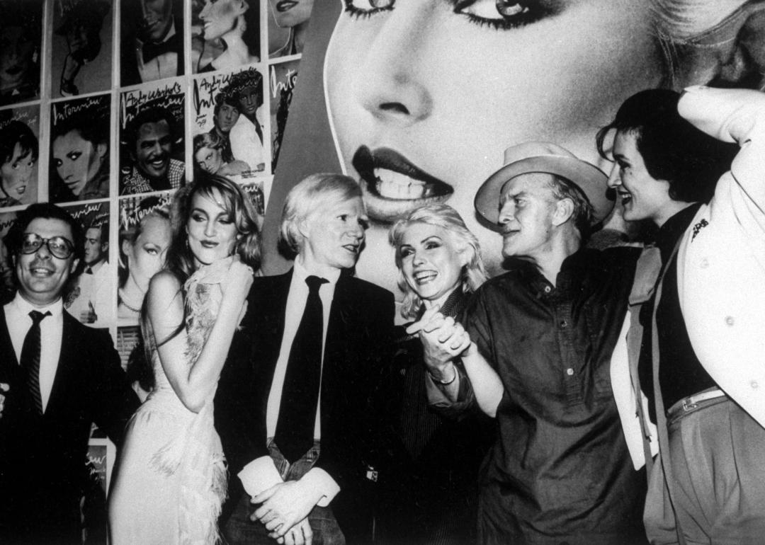 Bob Colacello, Jerry Hall, Andy Warhol, Debbie Harry, Truman Capote and Paloma Picasso at a party.