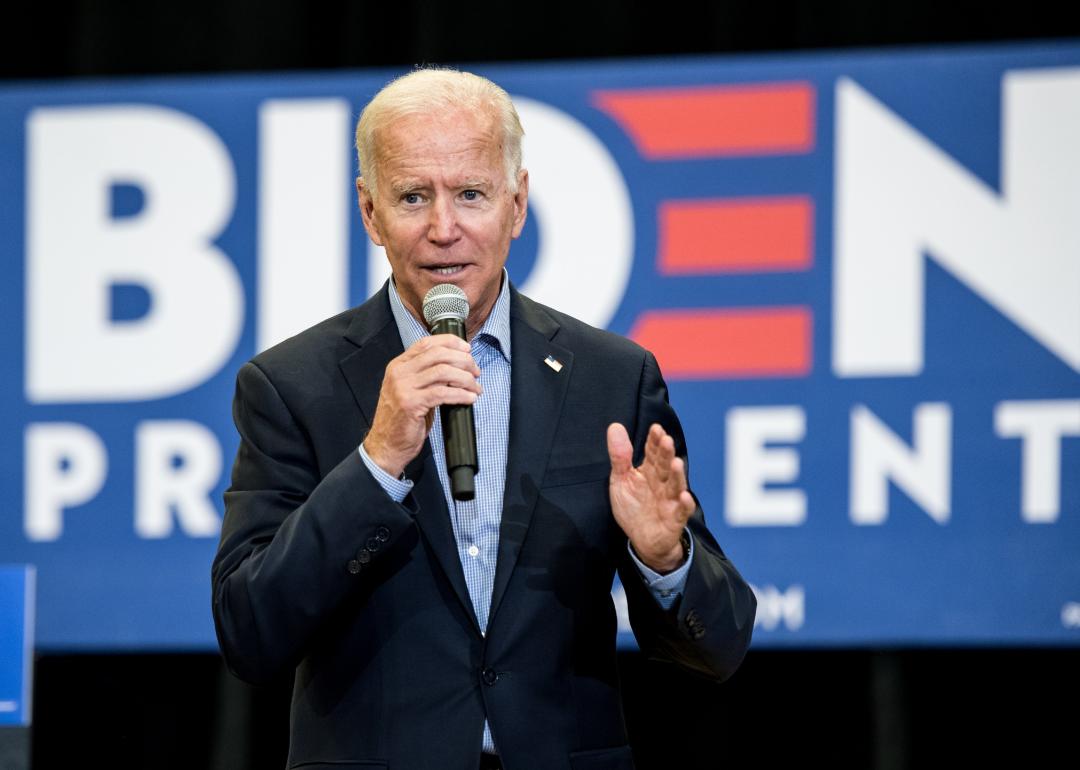 Joe Biden speaking on stage in front of a partially visible sign that reads Biden President. 