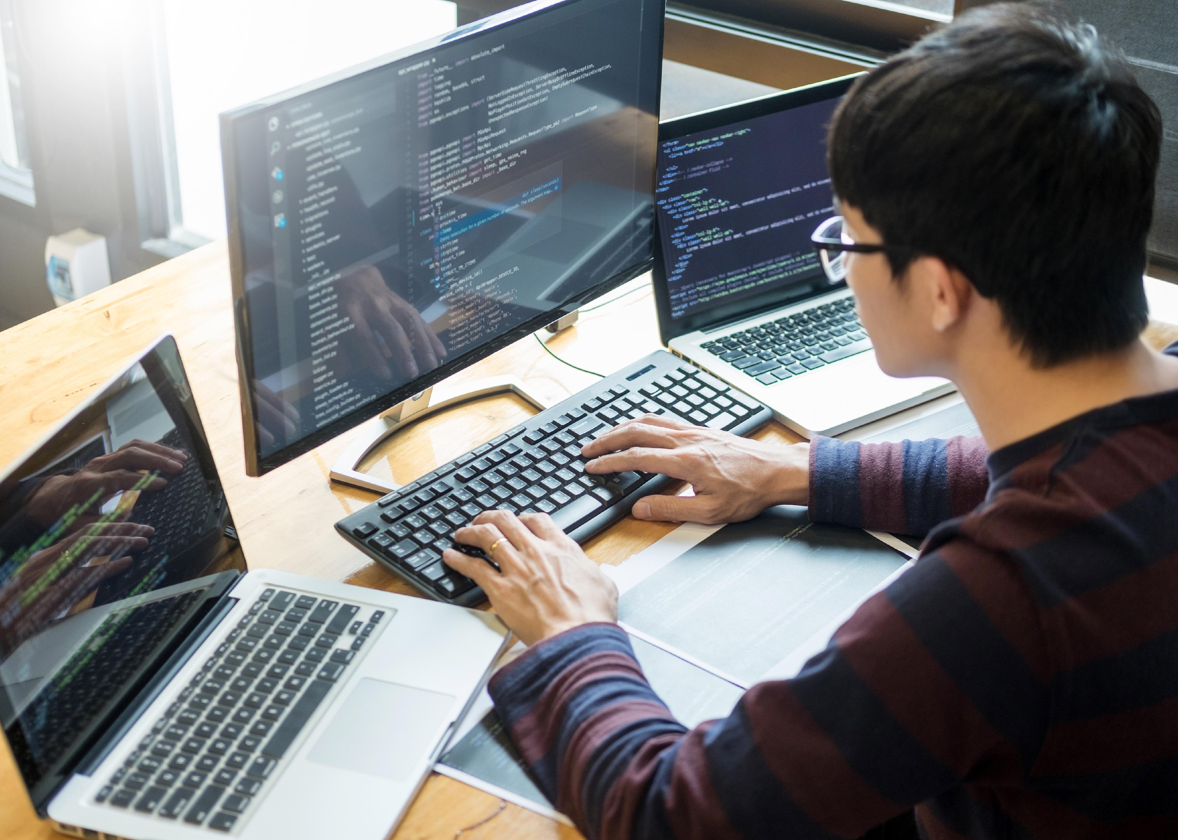 Programmer working on on desktop programming code.