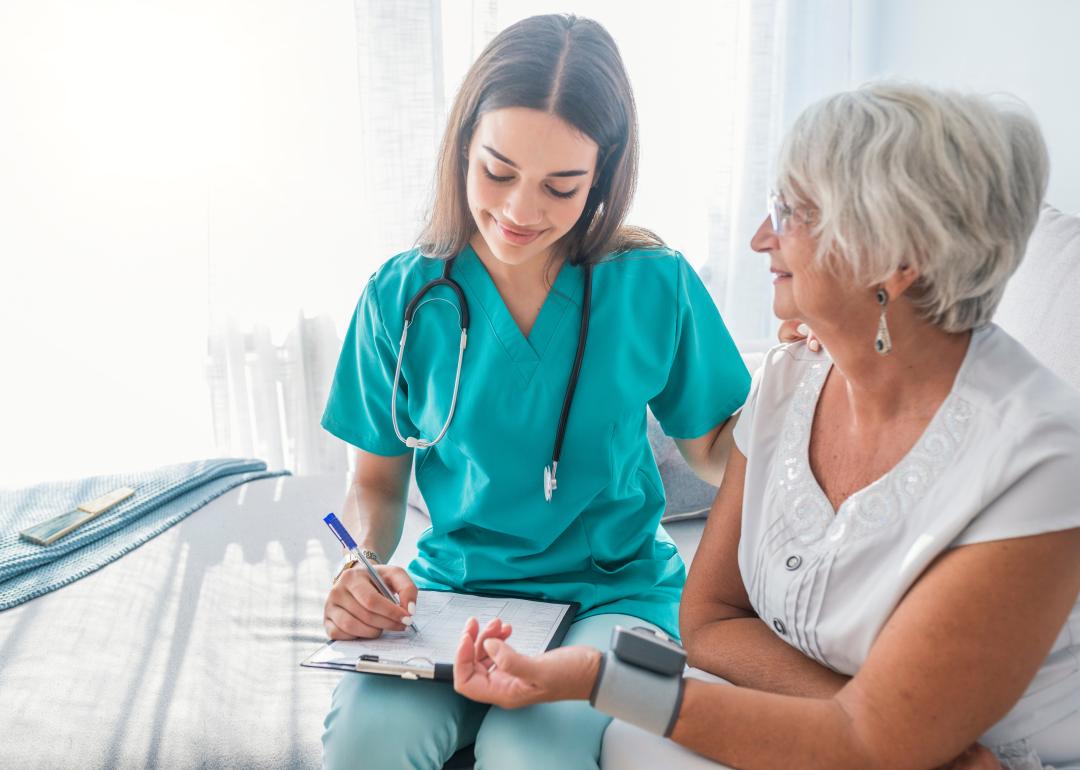 Nurse measuring the blood pressure of an older woman.