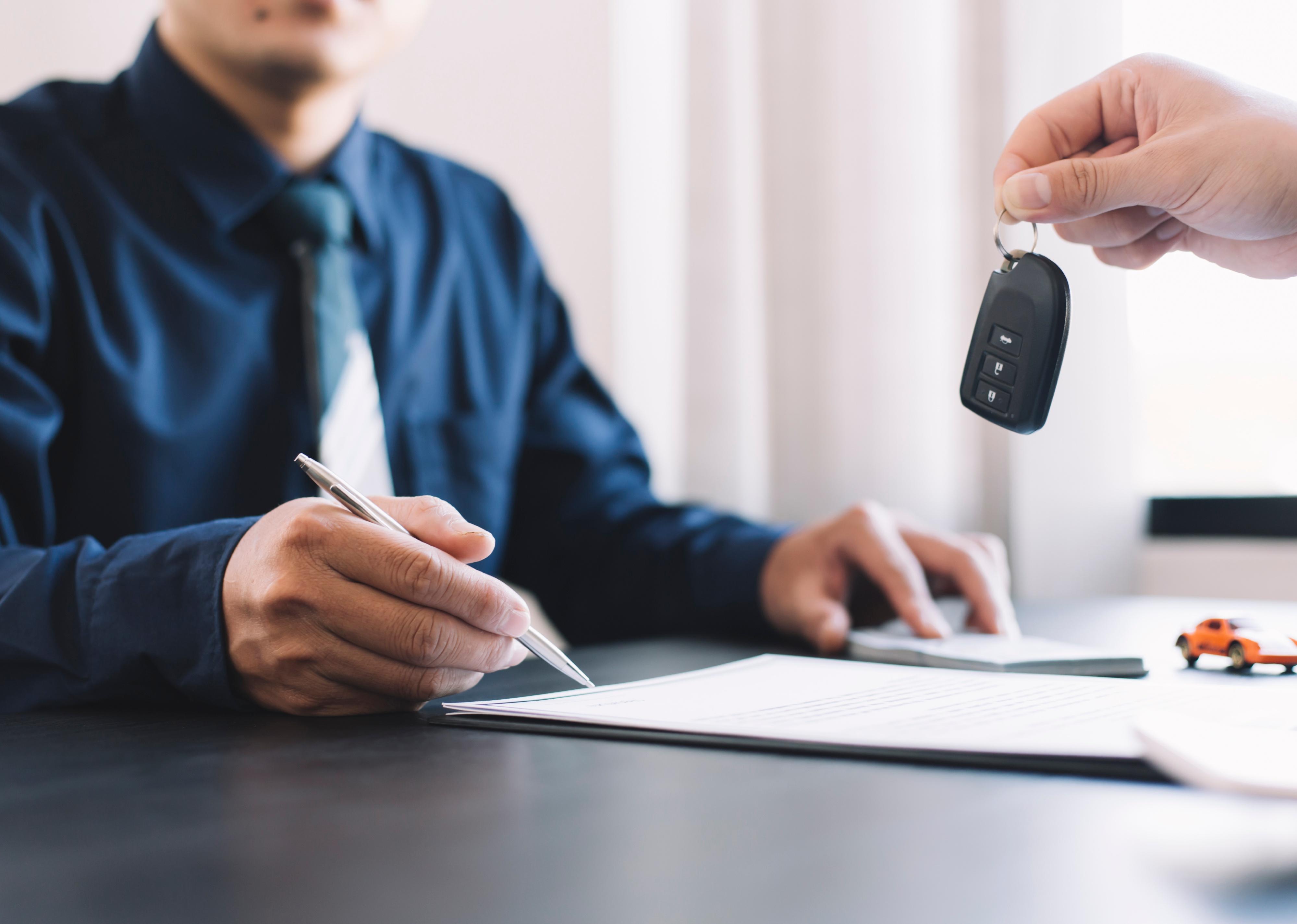 Car salesman handing over new car keys