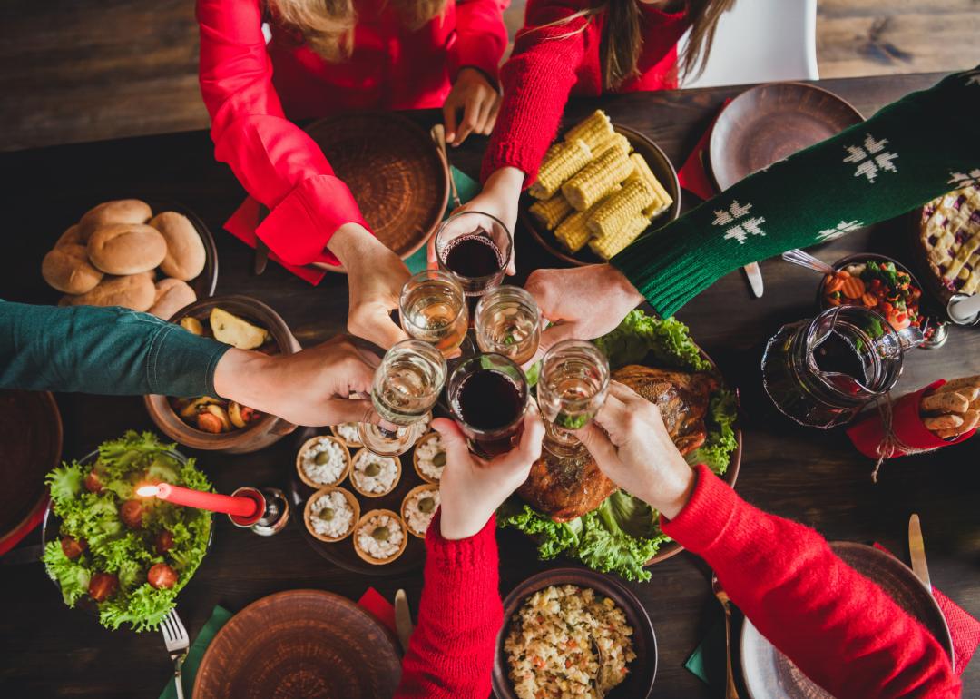 Top view of a group celebrating over a festive dinner table.