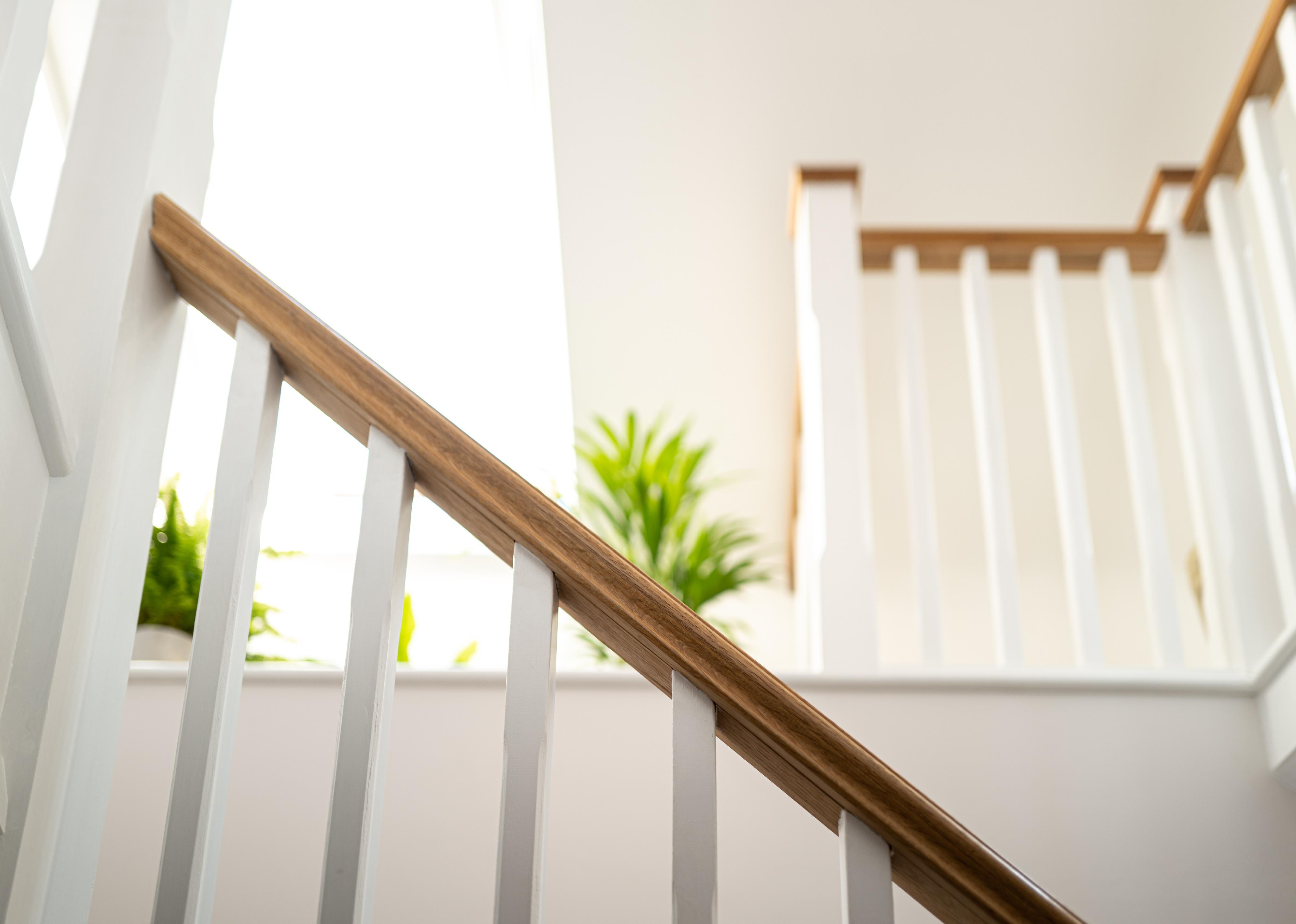 Wooden stair banister looking into a converted loft.