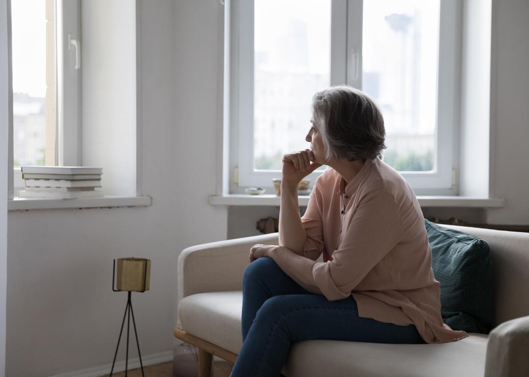 Mature gray-haired lady looking out window.