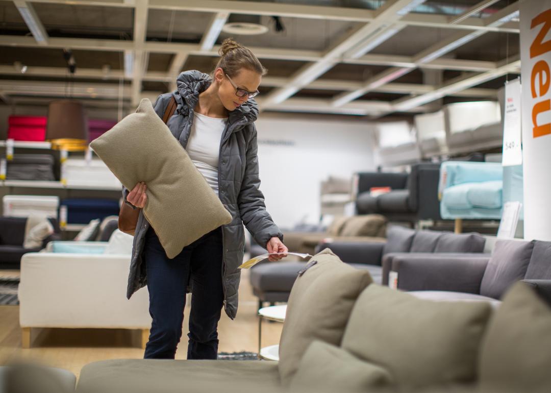 Young woman shopping for a couch in a home furnishings store.