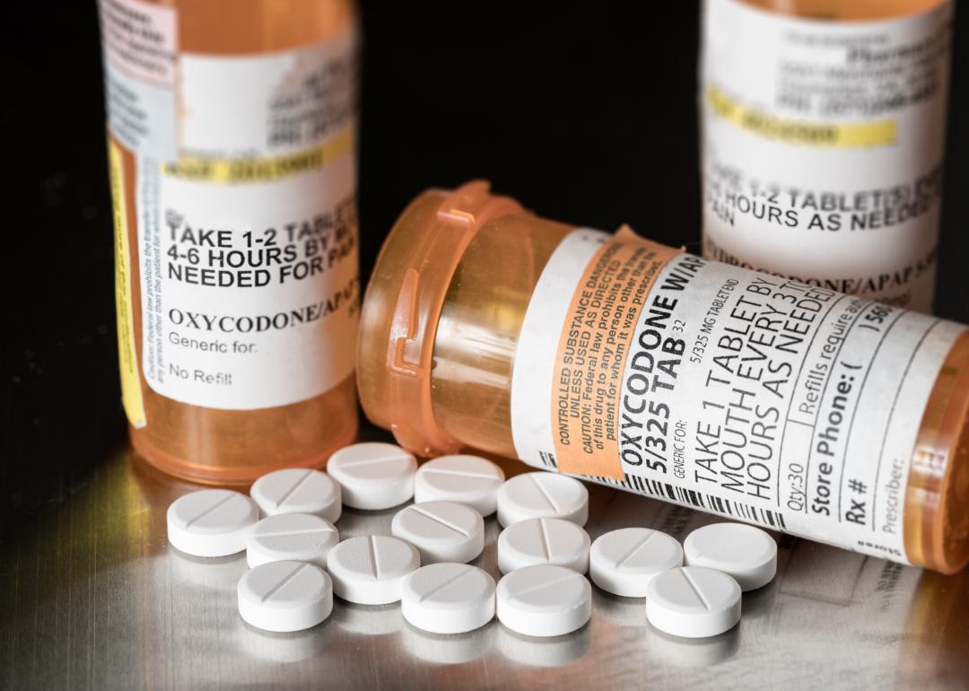 Prescription bottle for Oxycodone tablets and pills on metal table.