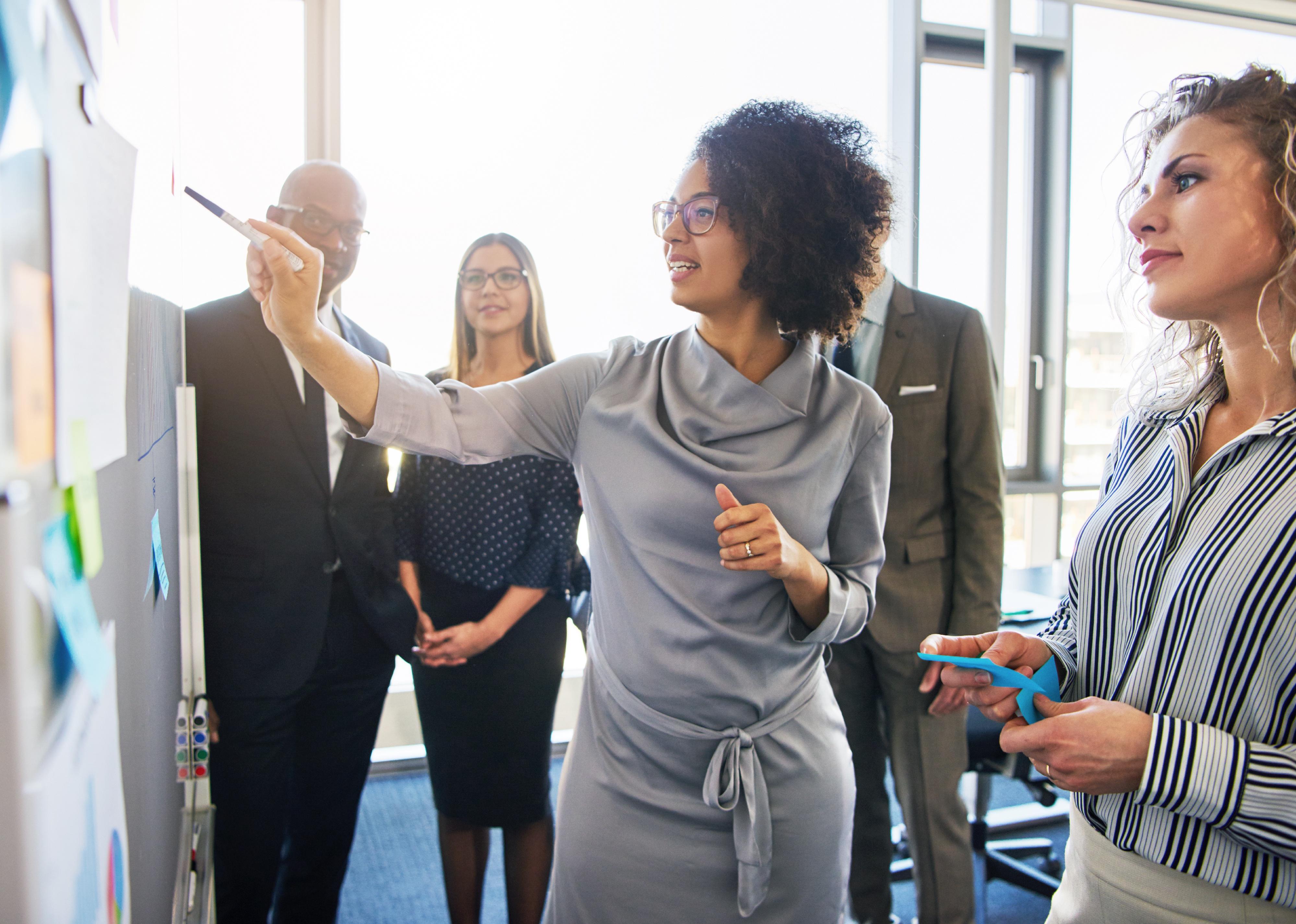 Group of businesspeople brainstorming together on a whiteboard