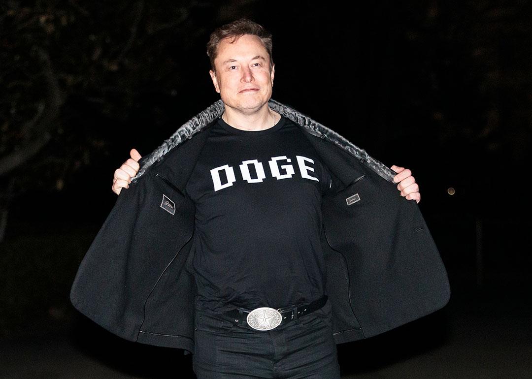 Elon Musk reveals a DOGE t-shirt and a Tesla belt buckle before entering the White House on March 9, 2025.