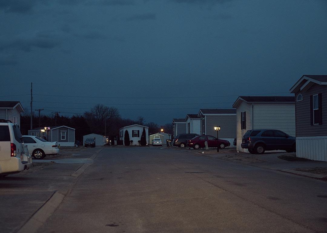Dusk falls on cars parked next to mobile homes in a mobile park owned by a private equity firm in Smyrna, Tennessee. 