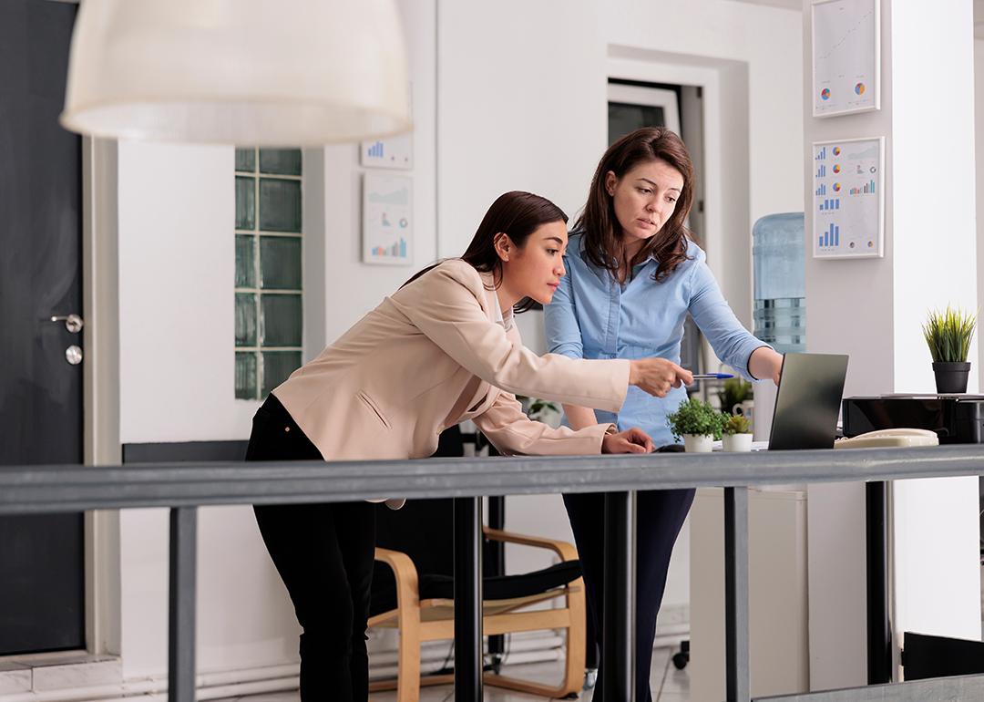 Two female coworkers discussing a company report.