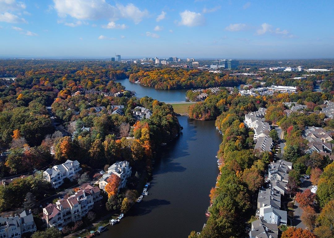 Aerial view of colorful fall trees surround lakes and homes in Fairfax County, Virginia.