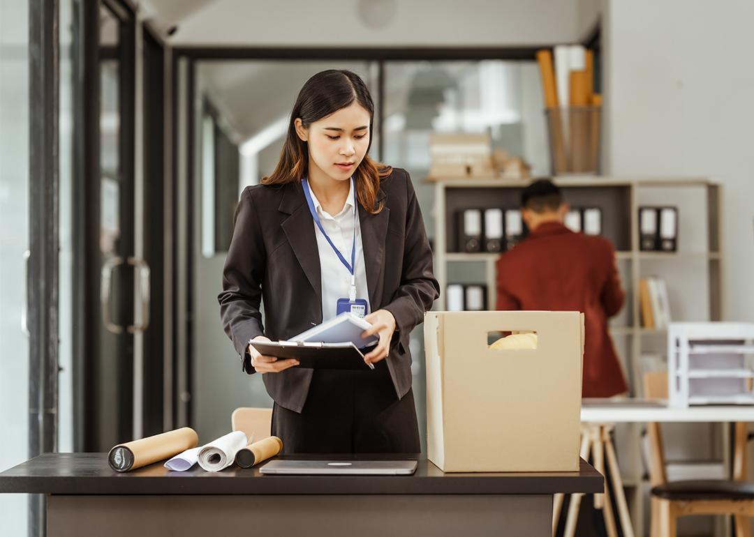 Young businesswoman preparing her work items to put in a box after being laid off.