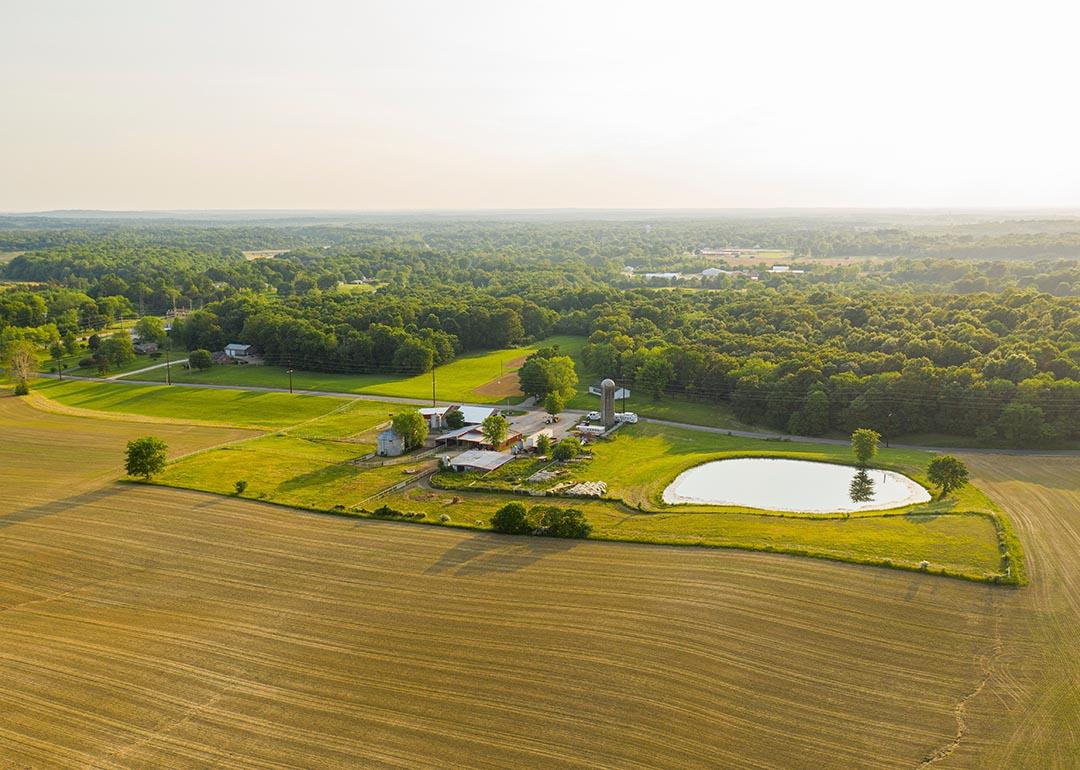 An aerial view of a small farm in southern Indiana during golden hour on a sunny summer day.