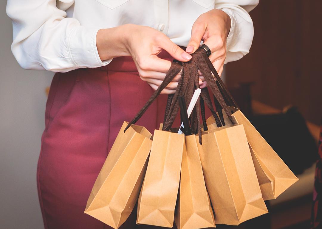 Employee holding corporate gift bag packages.