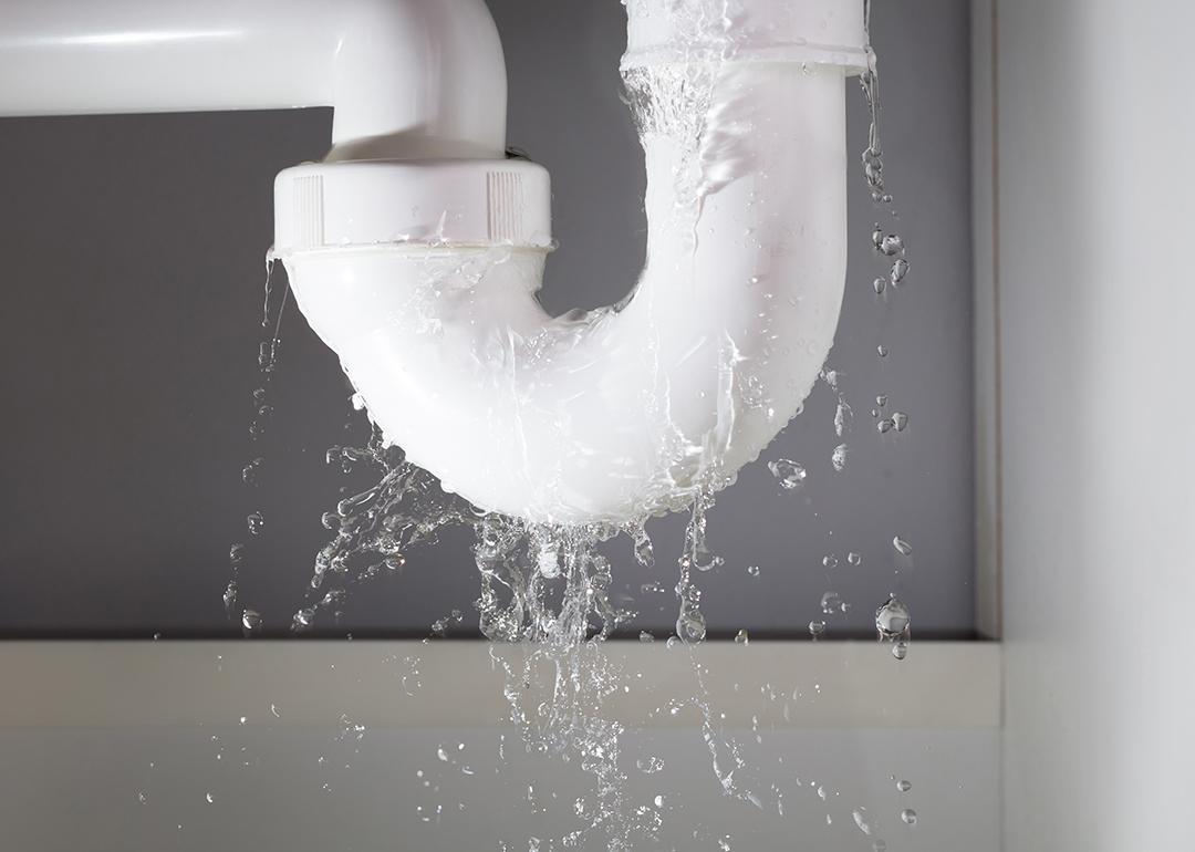 Close-up of a water pipe from under the sink leaking.