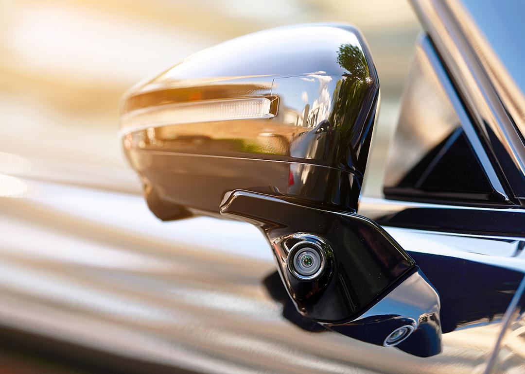 Side area of a car showing the rear mirror for blind spot monitoring.