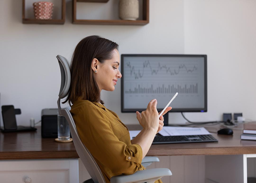 A female finance trader using her smartphone at work.