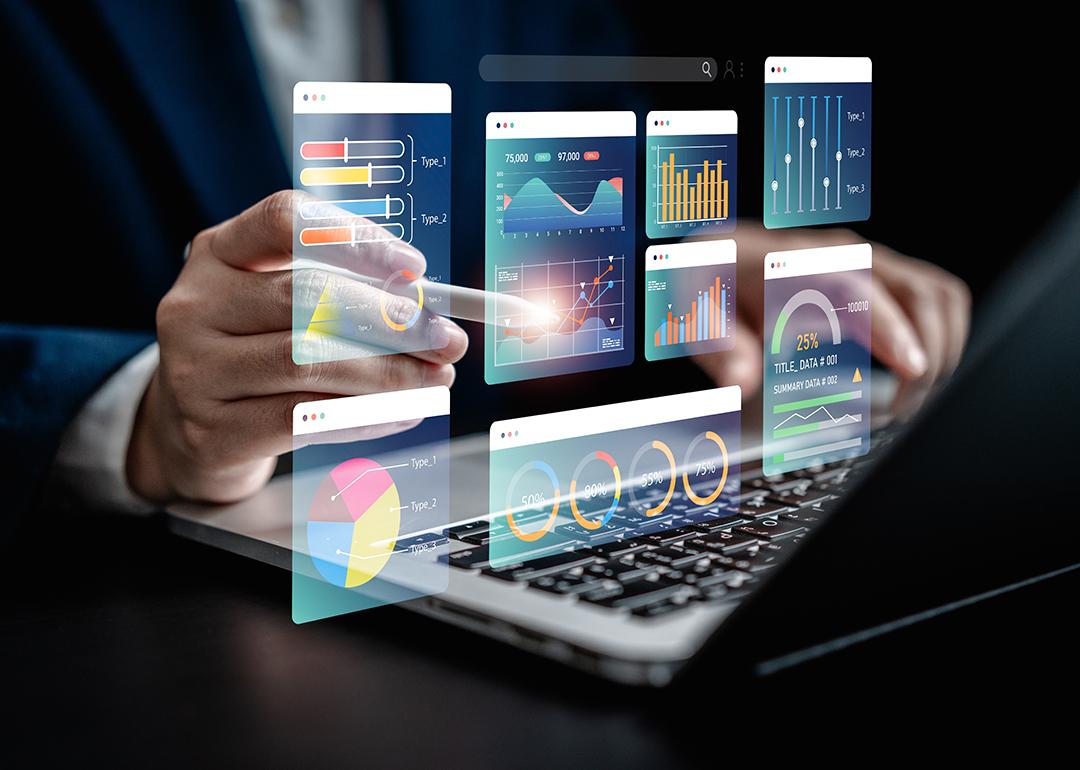 Businessman using a laptop with illustratons of finance software, charts and dashboard graphics.