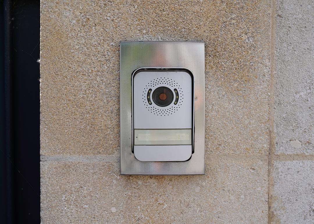 A surveillance video doorbell on a modern house's door.