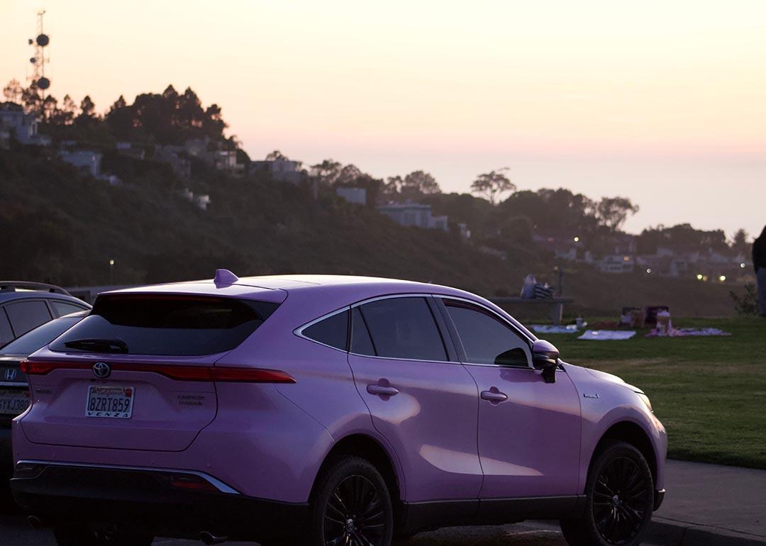 Pink toyota venza that looks lavender parked at mount soledad in san diego during sunset golden hour.