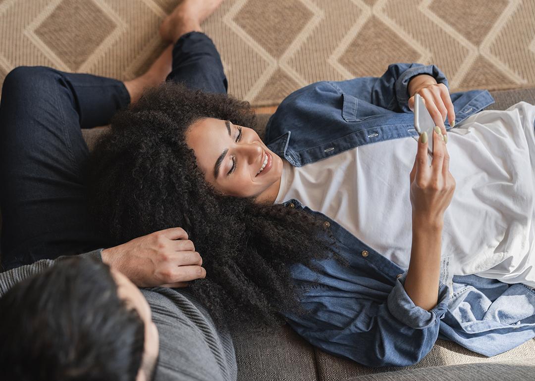 Young couple at home browsing information using a phone.
