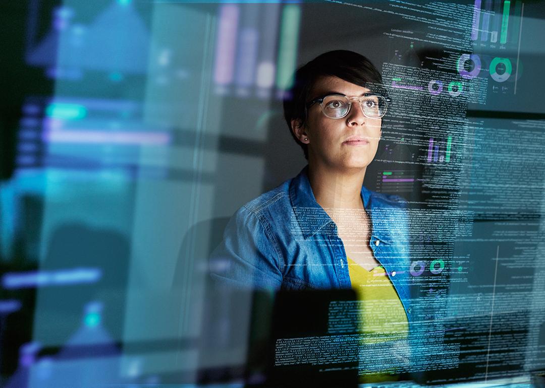 A young female computer programmer looking through data.