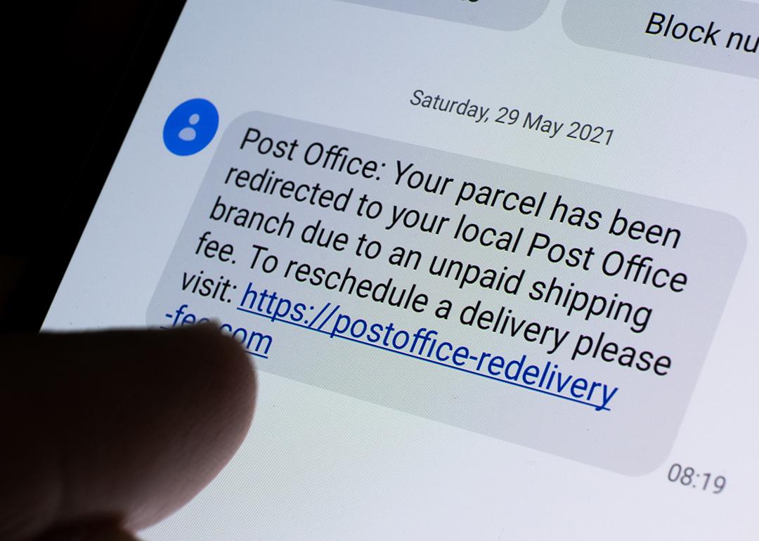Phone displaying a USPS scam text message with a link.