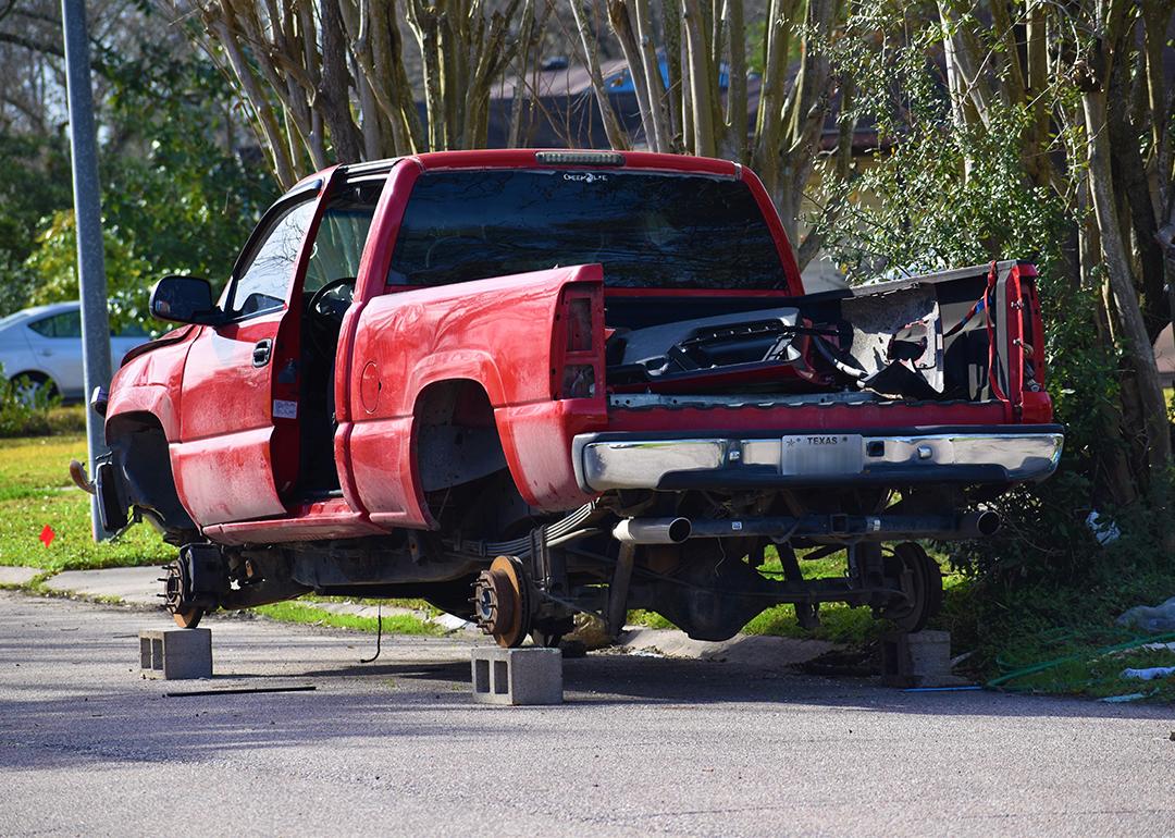A stolen red pick-up truck in Texas, stripped and hoisted with bricks.