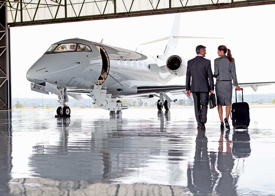 A pair of business people walking towards a private plane.
