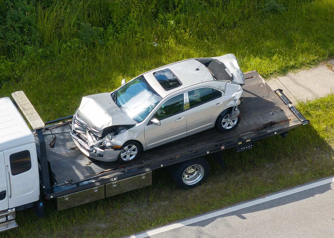 A damaged car loaded on a tow truck from the accident site.