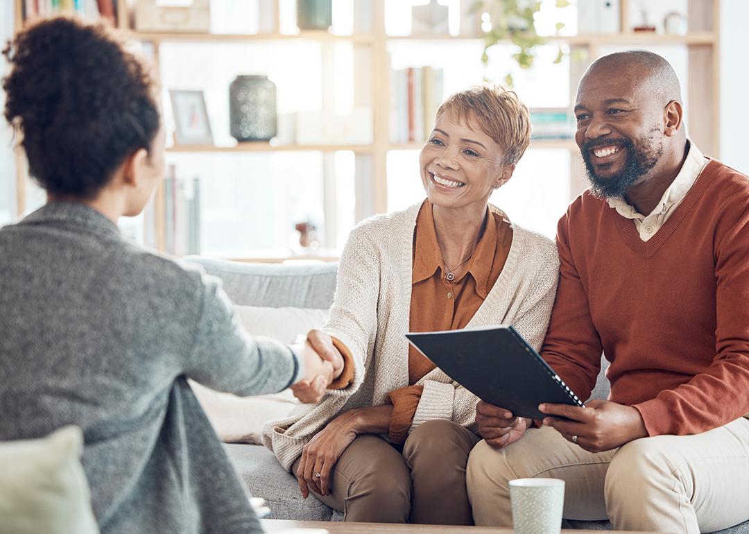 A couple shaking hands with a financial advisor.
