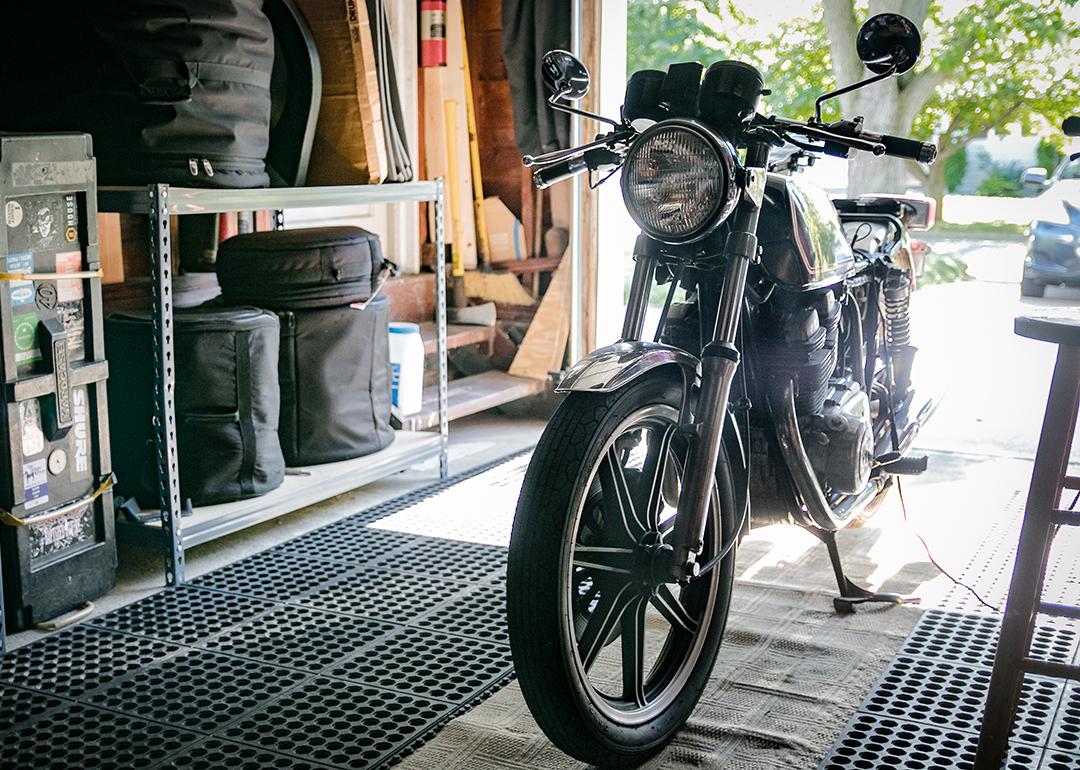 A black vintage motorcycle stored in an open garage.