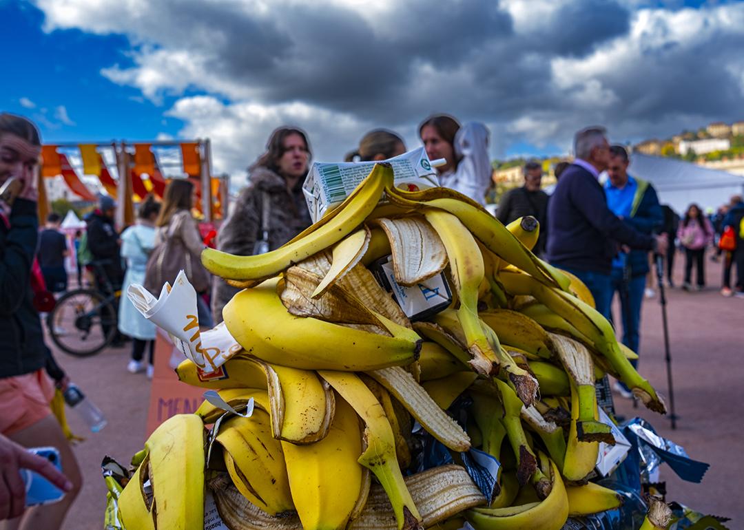 A pile of banana peels in the trash during a marathon in a city.
