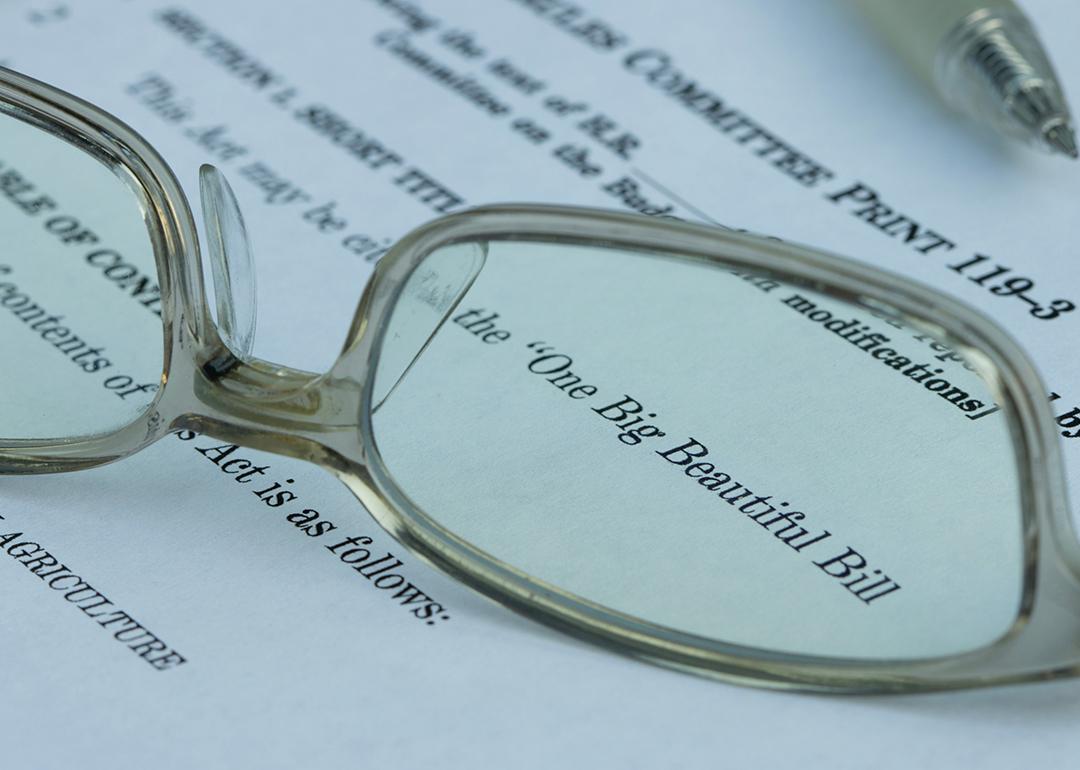 A pair of eyeglasses magnified on the words 'One Big Beautiful Bill' (Act) on a document.