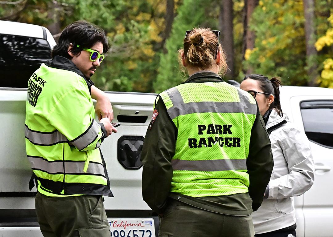 Three park rangers behind their car on duty at Curry Village in the Yosemite Valley at Yosemite National Park, California.