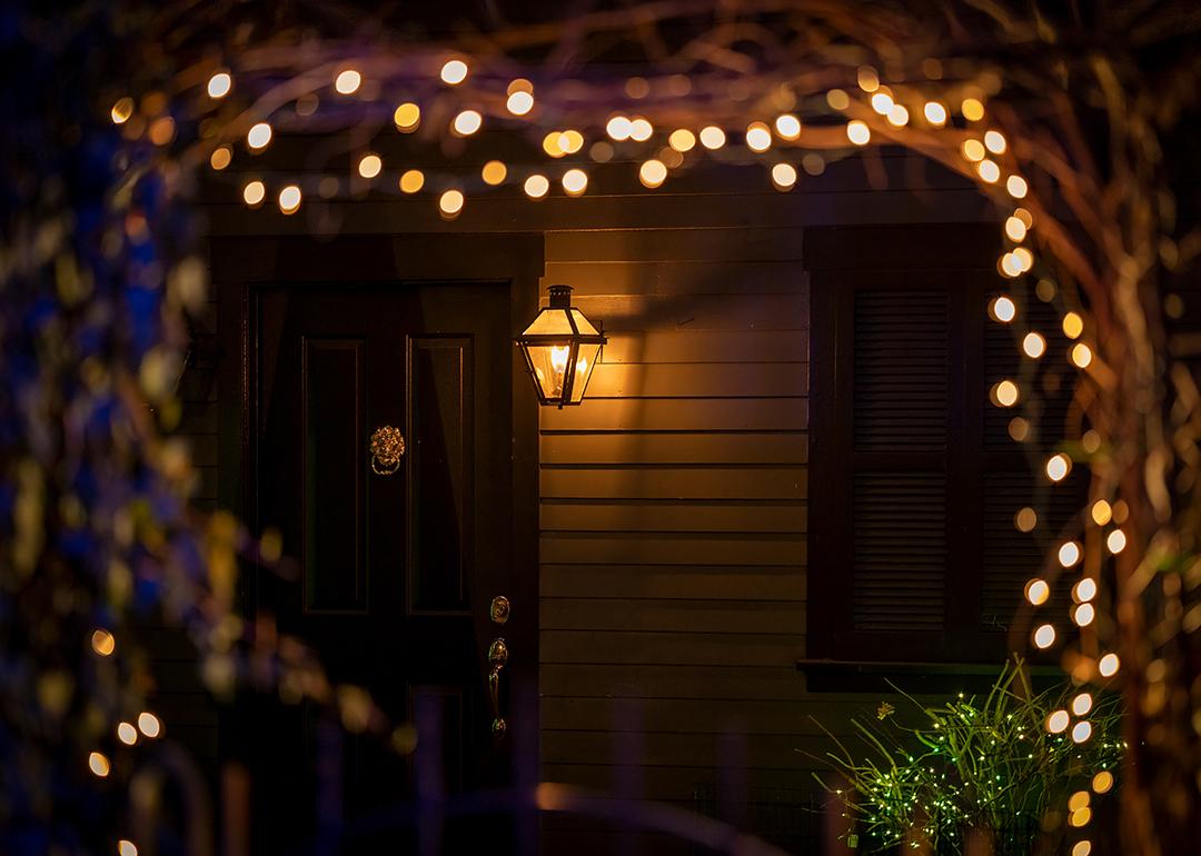 Holiday lights during night designed around an arch leading to a house's doorway.
