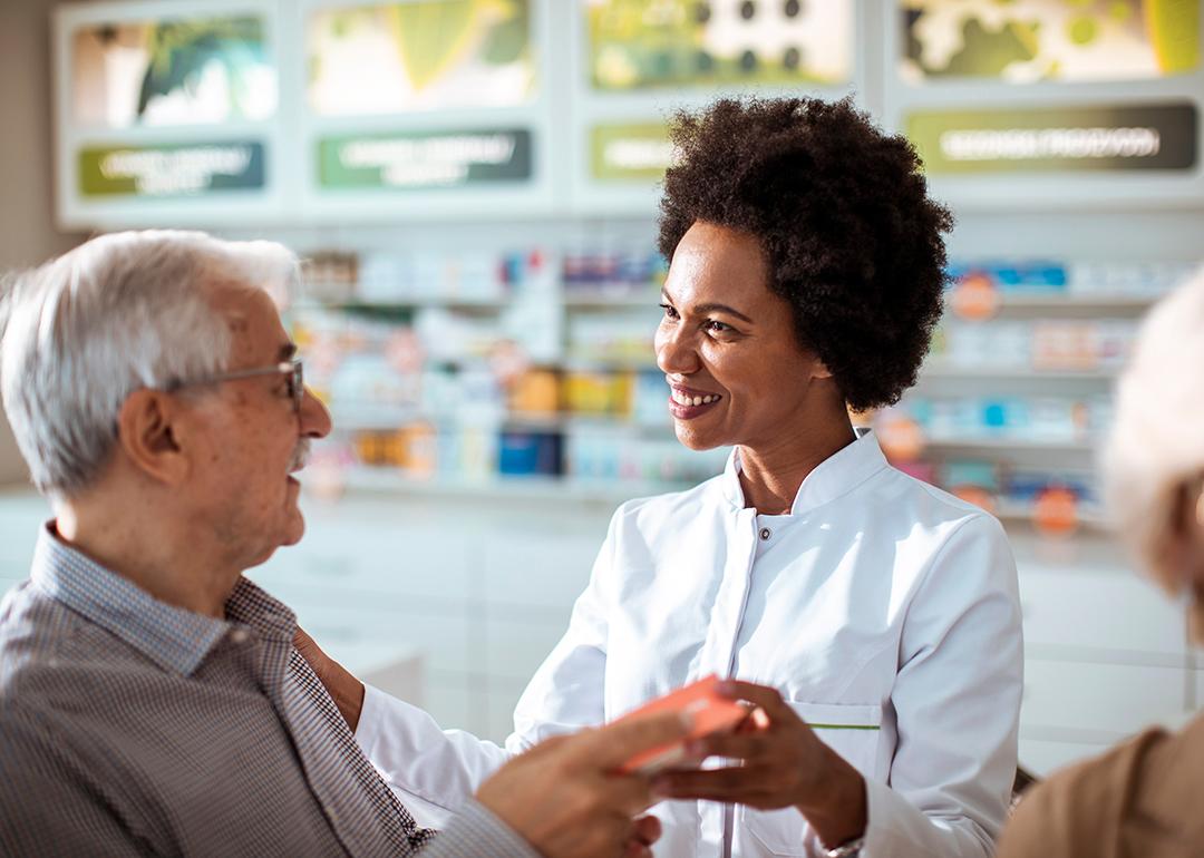 A female pharmacist helping senior customers.