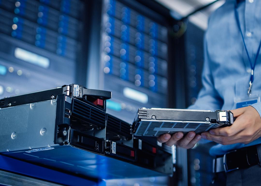 An IT engineer preparing to install new hardware into a server pack.