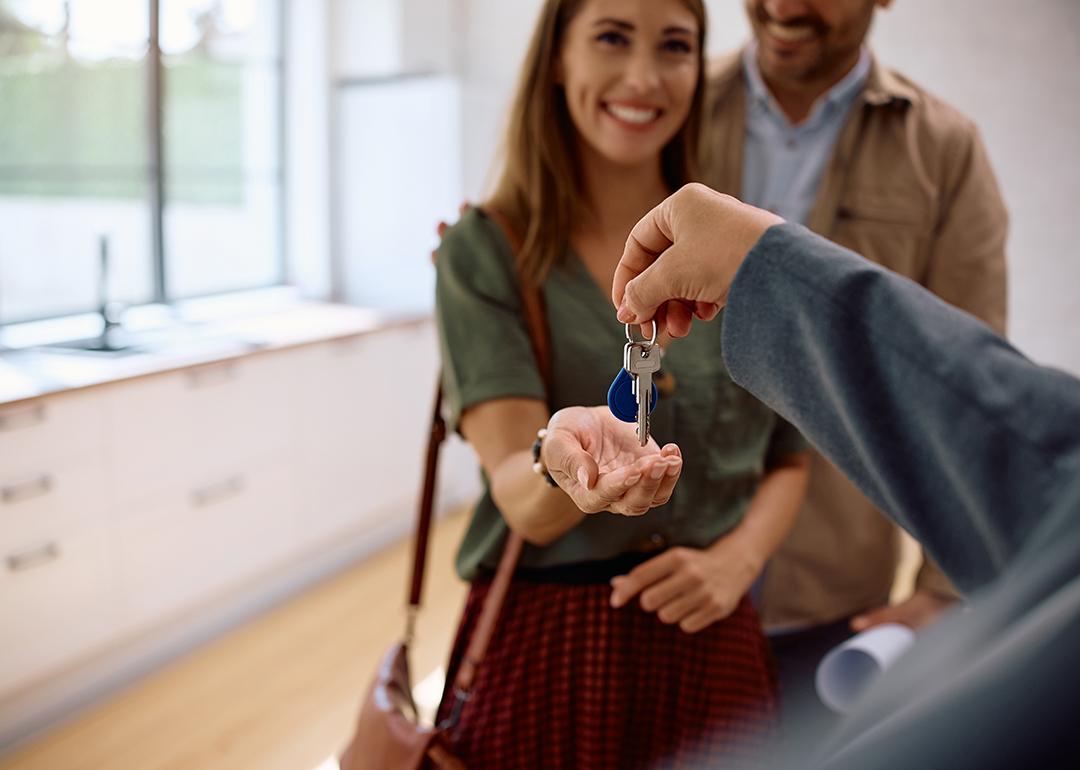 A real estate agent handing over house keys to a new couple.