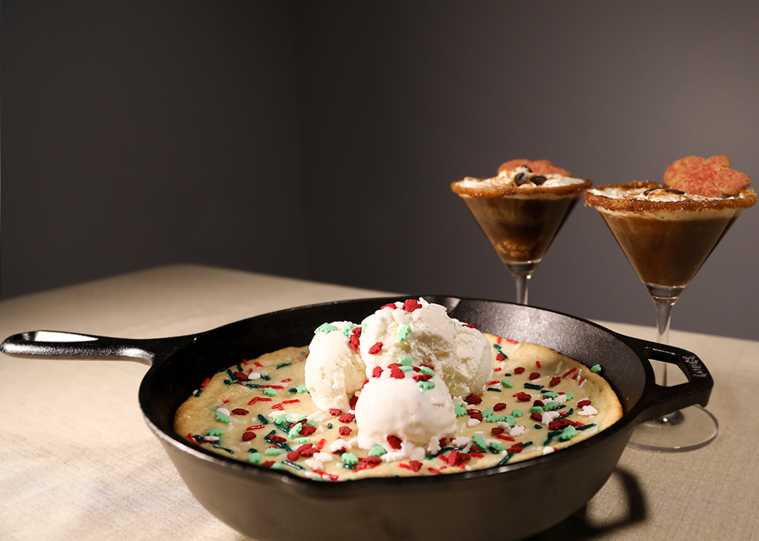 A 'Winter Wonderland' Sugar Cookie on a skillet with two glasses of Gingerbread Espresso Martini.