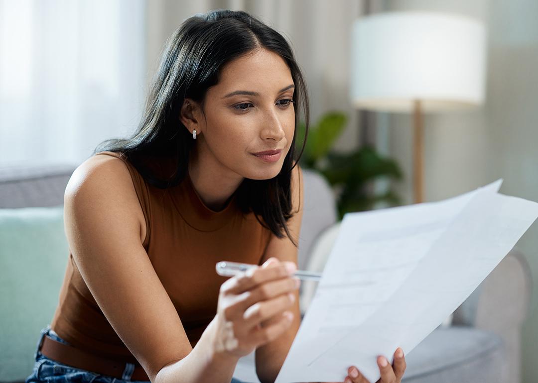 Woman checking bills in the living room.