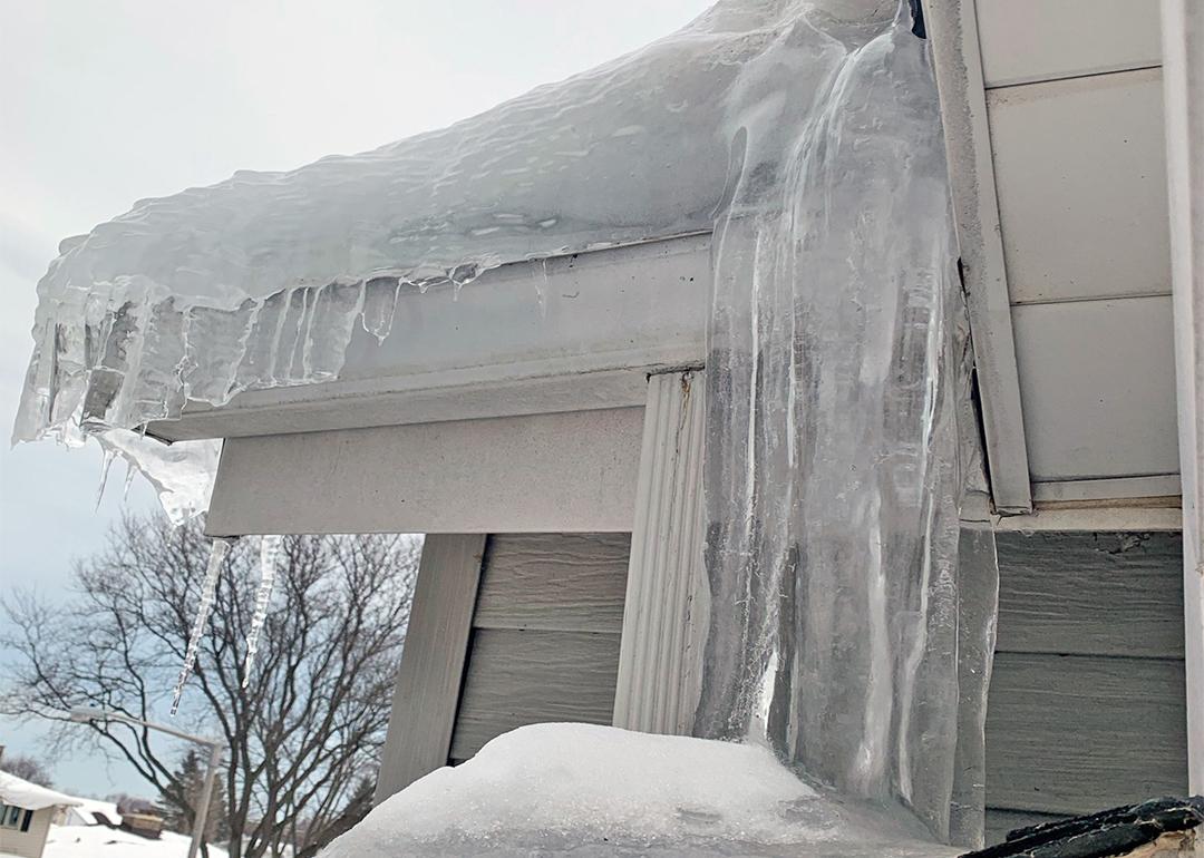 Thick ice dam formed on a house's roof.
