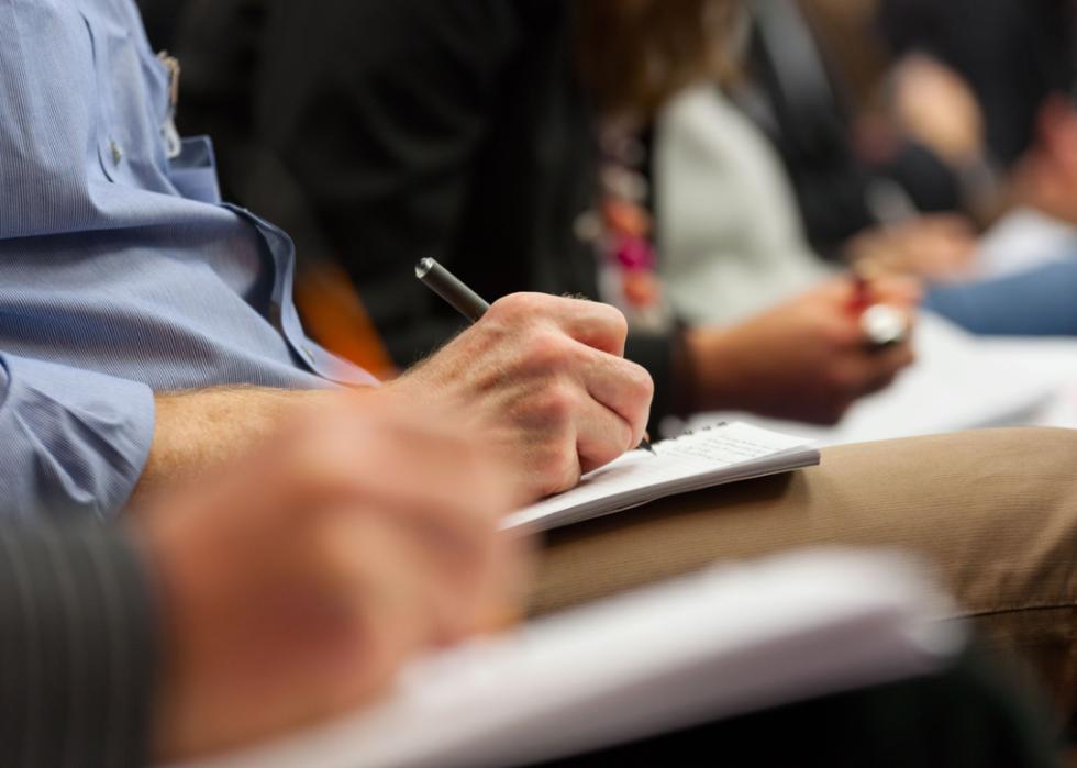 Hand holding pen and taking notes.