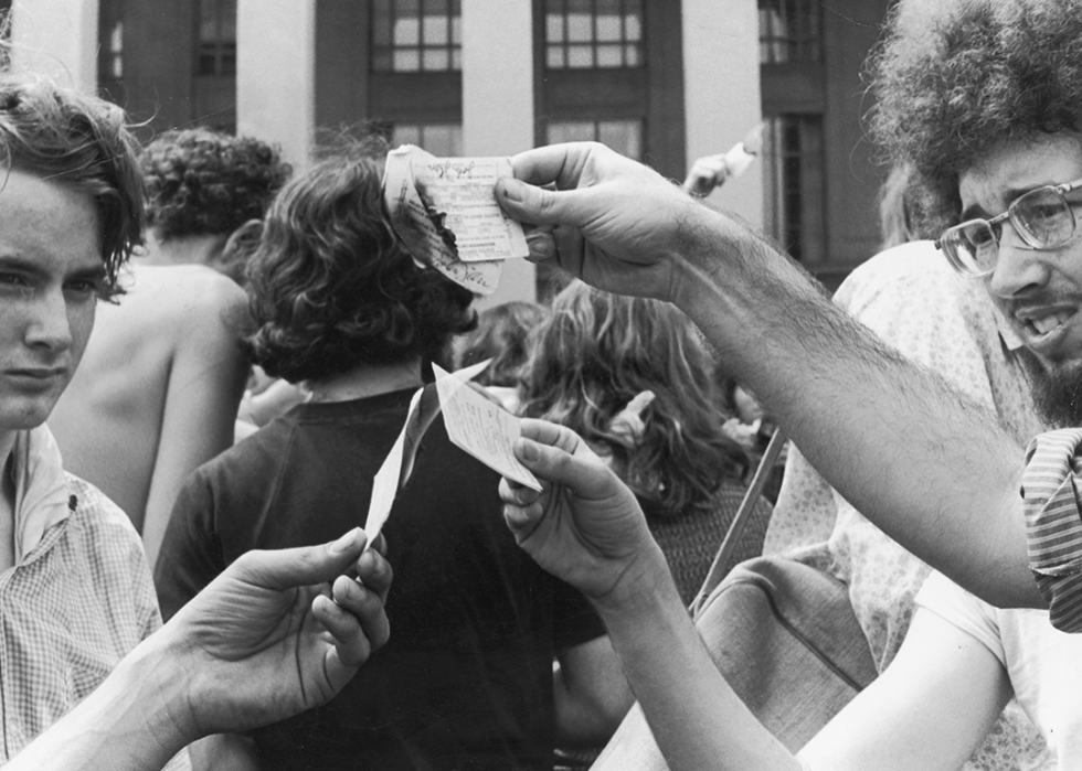 Antiwar demonstrators burn draft cards.