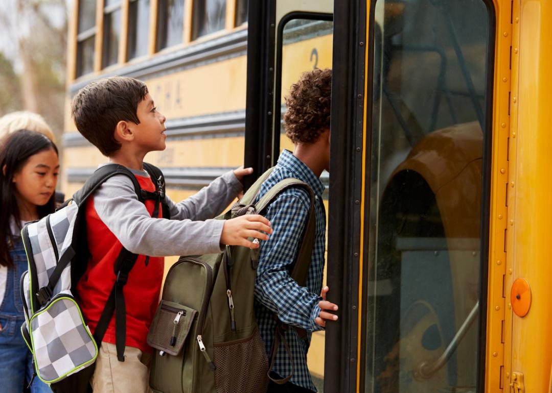 Group of elementary school students getting on bus.